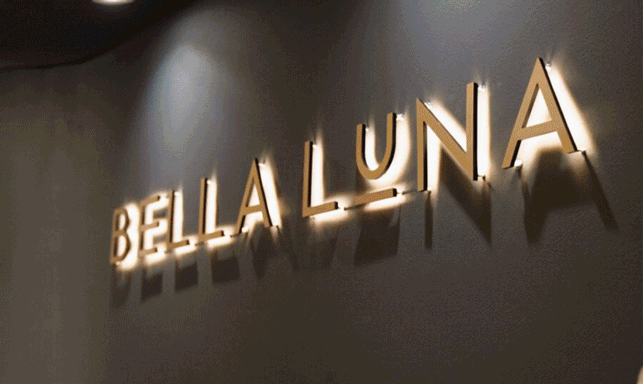Elegant illuminated sign of 'Bella Luna' on a stylish wall, perfect for ambiance and branding.